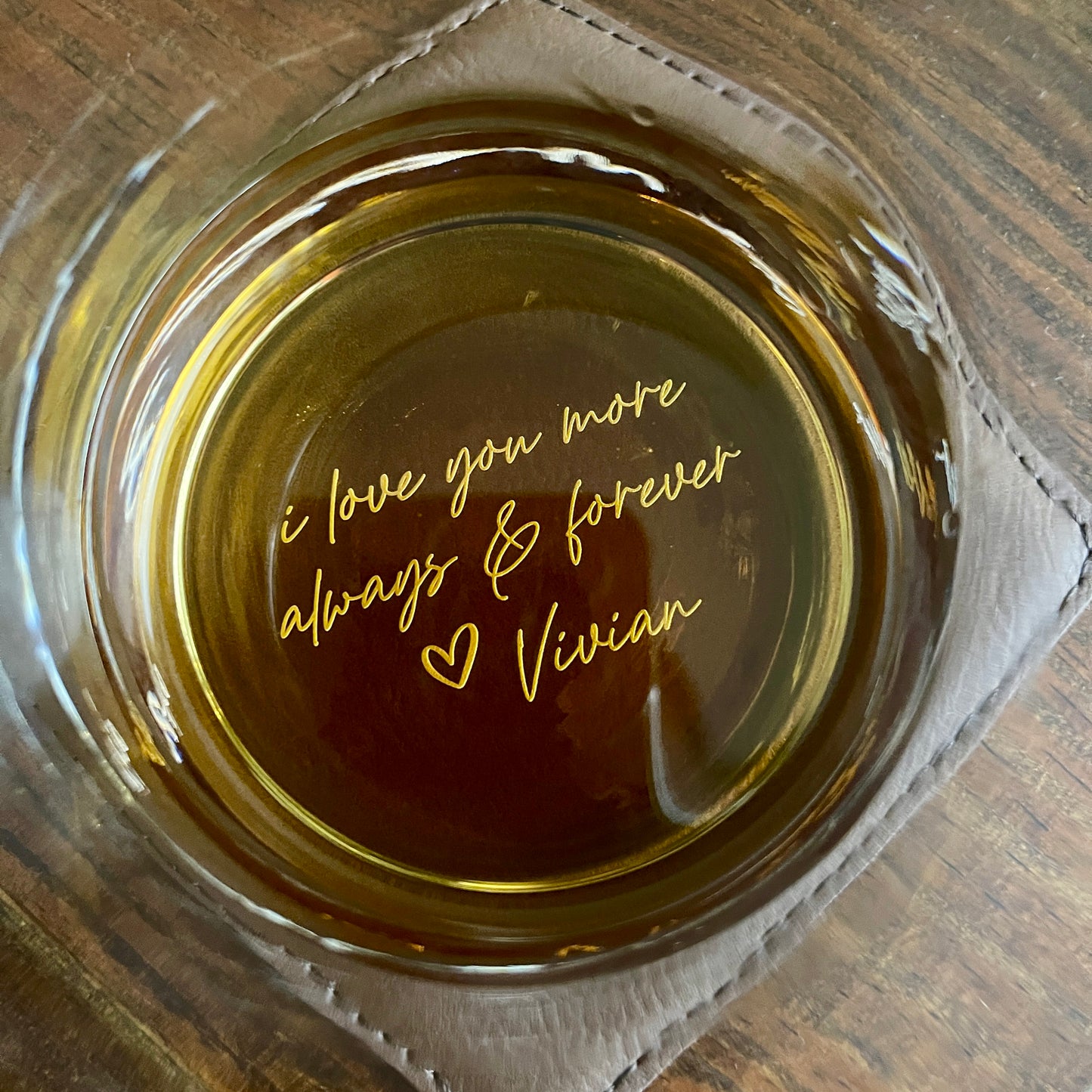 Whiskey rocks glass with a Personalized laser engraved message on a wooden surface
